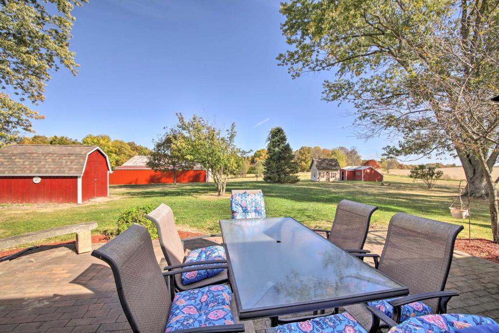 a patio with a table and chairs and a barn at Scenic Gosport Getaway, Over 100 Years Old 