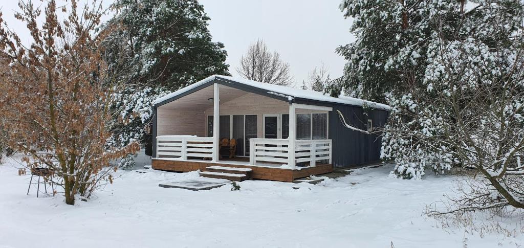 a small cabin in the snow with snow covered trees at Відпочинково-ресторанний комплекс "Затишна садиба" in Luchin