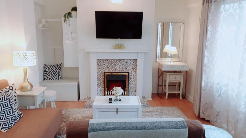 a living room with a fireplace with a tv above it at 2 Bedroom Apartment Central City Centre I Free Netflix in Birmingham