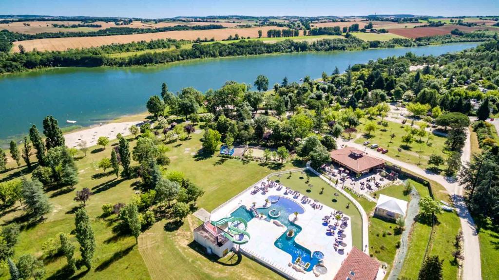 an aerial view of a resort with a lake at Camping le Lac de Thoux in Saint-Cricq