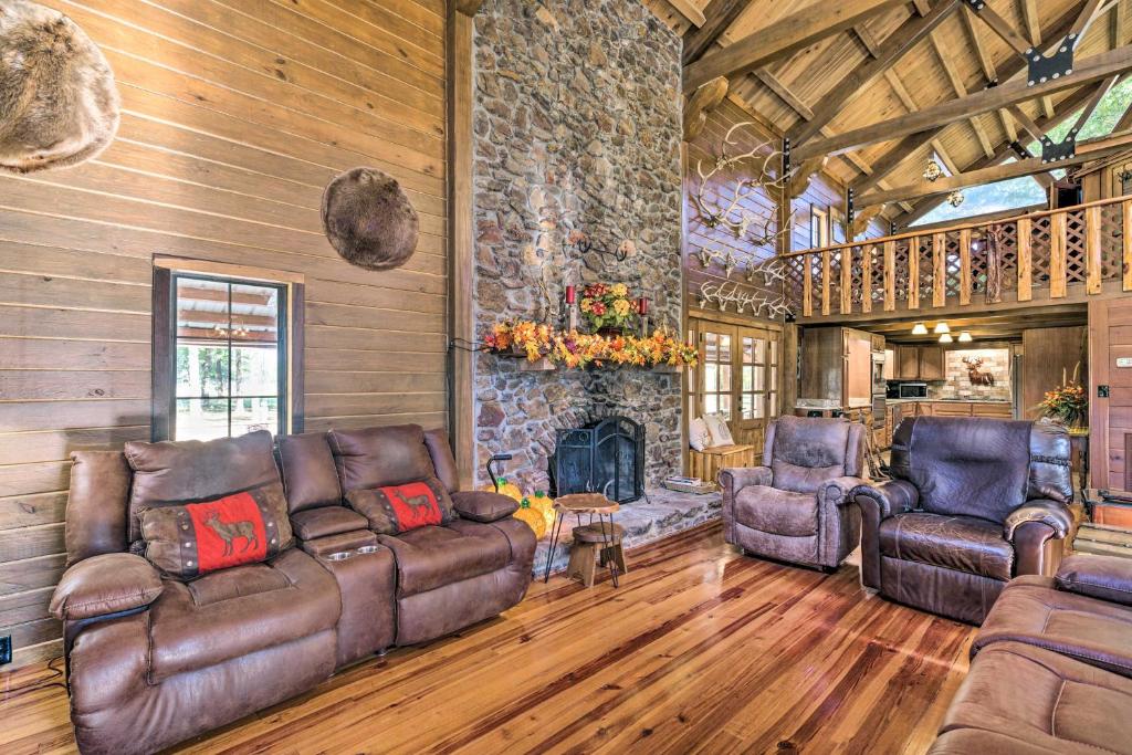 ein Wohnzimmer mit Ledermöbeln und einem Steinkamin in der Unterkunft Countryside Cabin Retreat with Outdoor Kitchen! 
