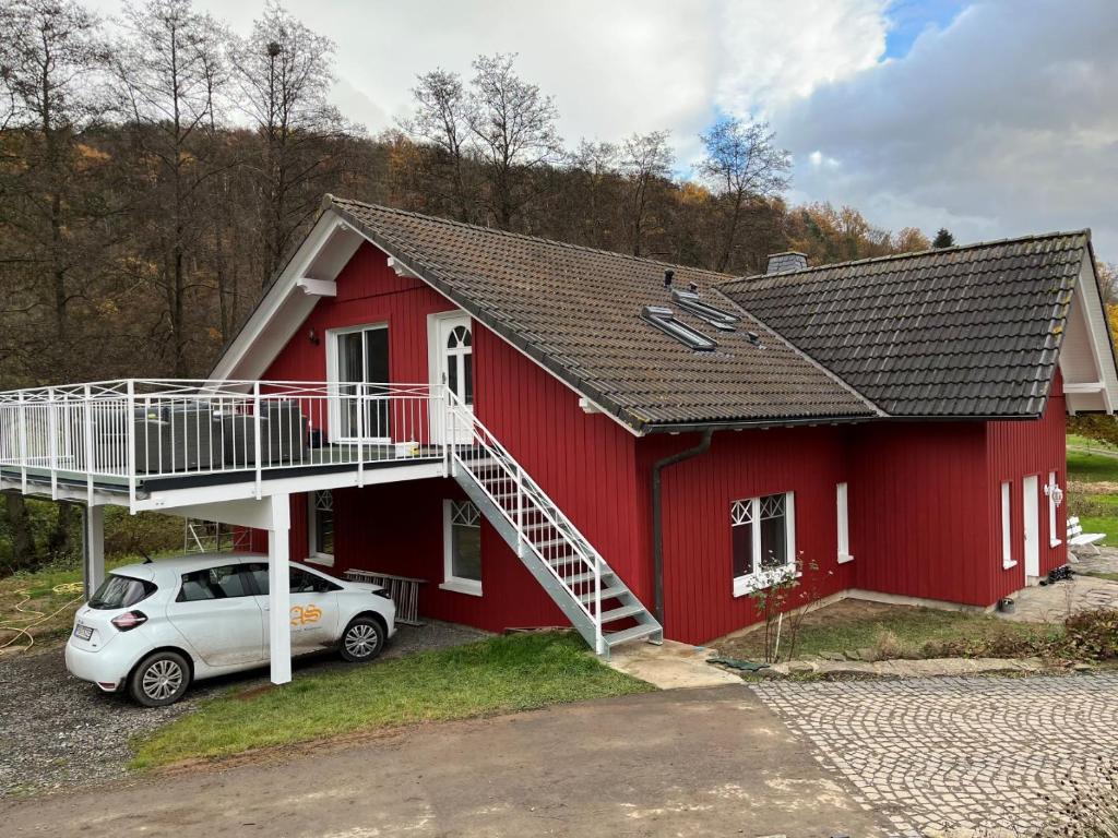 ein rotes Haus mit einem davor geparkt in der Unterkunft Reiterhof Füllnhausen in Kröge