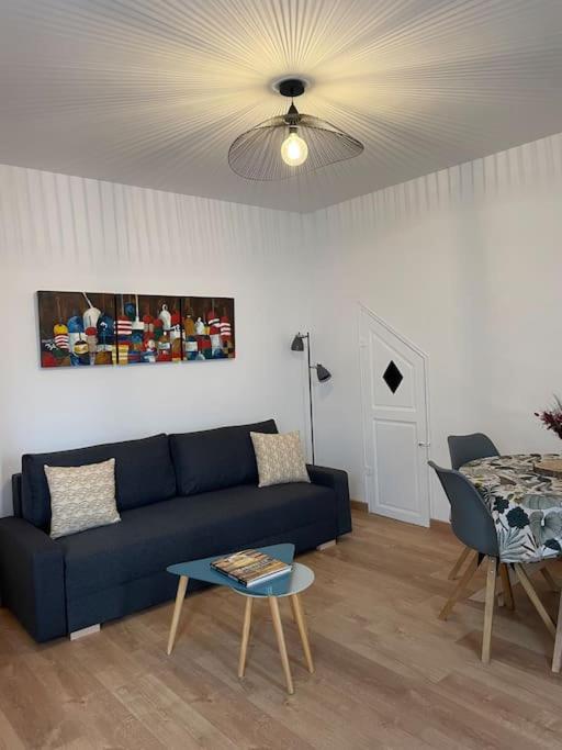 un salon avec un canapé bleu et une table dans l'établissement Pointe Rouge: Petit cocon entre mer et colline, à Marseille