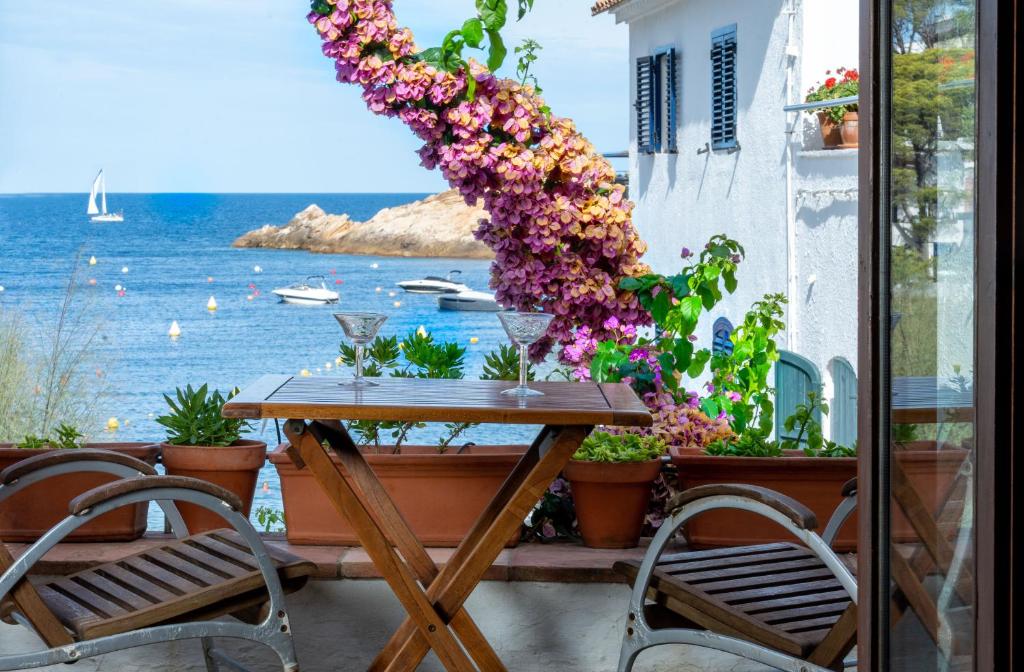 una mesa con flores en un balcón con vistas al océano en Flateli Sa Tuna 2, en Begur