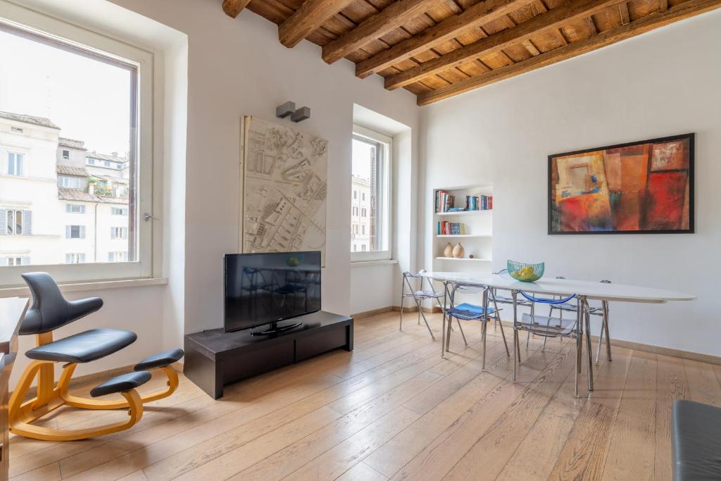 un soggiorno con tavolo, sedie e TV di Modern apartment in Campo de Fiori a Roma