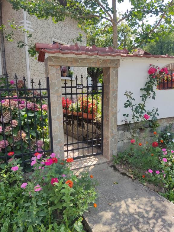 a gate to a garden with flowers at къща за гости Хайк in Beli Osŭm