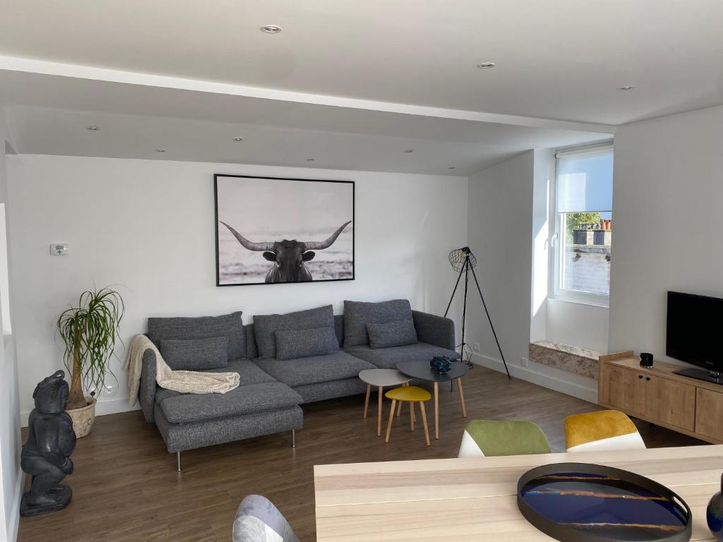 a living room with a couch and a cow on the wall at Appartement situé en centre ville super lumineux in Dunkerque