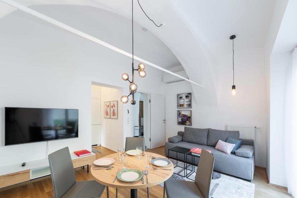 ein Wohnzimmer mit einem Tisch und einem Sofa in der Unterkunft Premium Apartments im Stadtzentrum in Graz