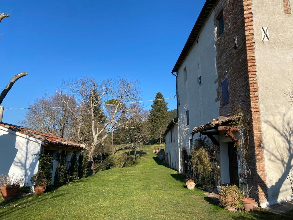 un viejo edificio de ladrillo con un patio de hierba al lado en Casa di Nonna Nuccia, en Fabriano