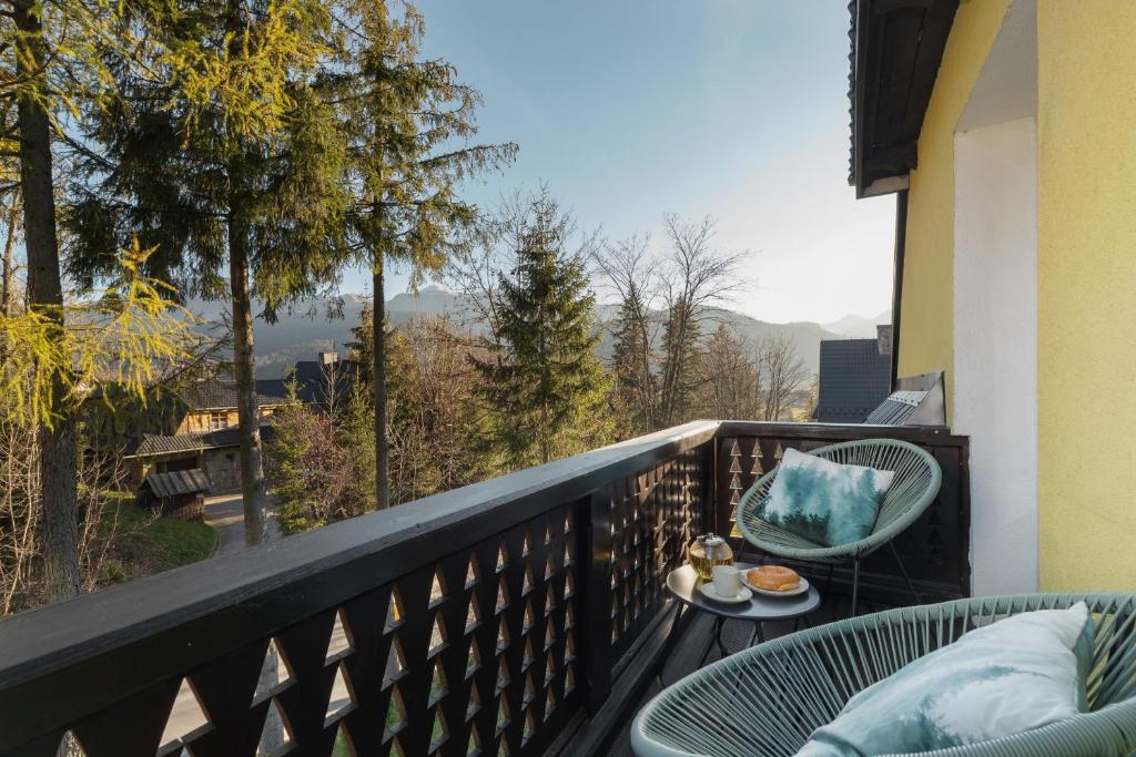 uma varanda com uma mesa e uma cadeira. em Apartament Salamandra Giewont View by Renters Prestige em Zakopane