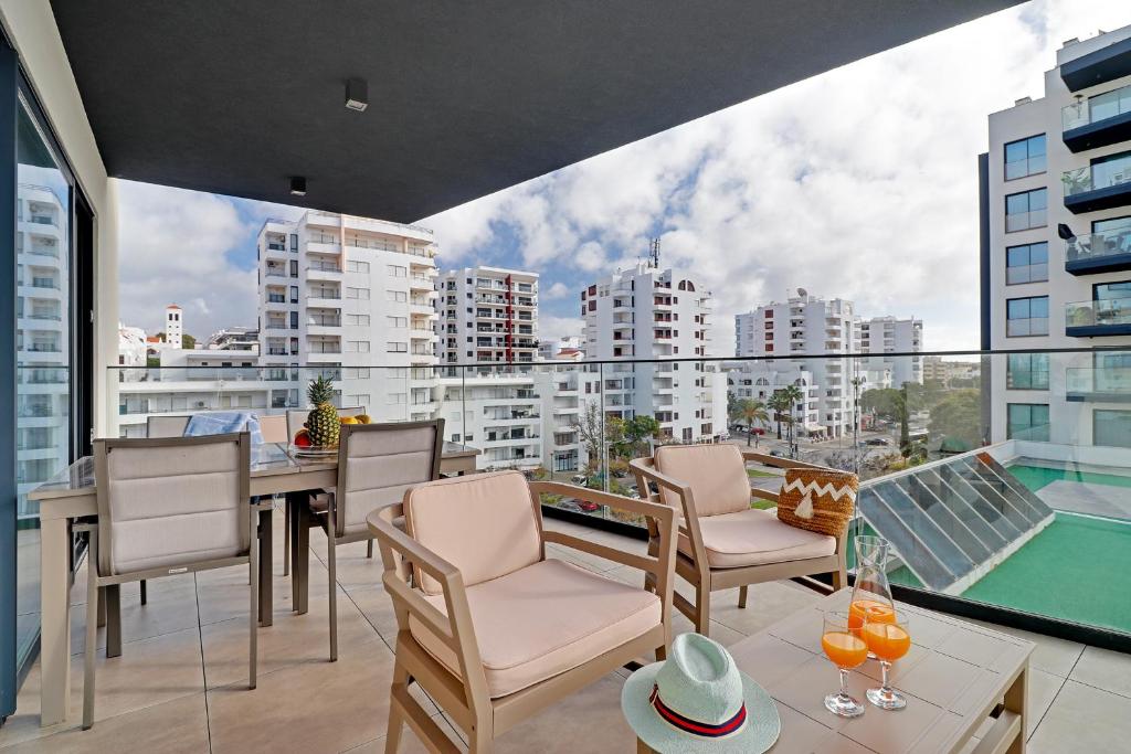 Un balcón con mesa y sillas y vista a una ciudad. en Sky Beach Apartment, en Quarteira