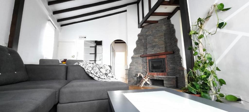 a living room with a couch and a stone fireplace at Villa Lucín in Santander