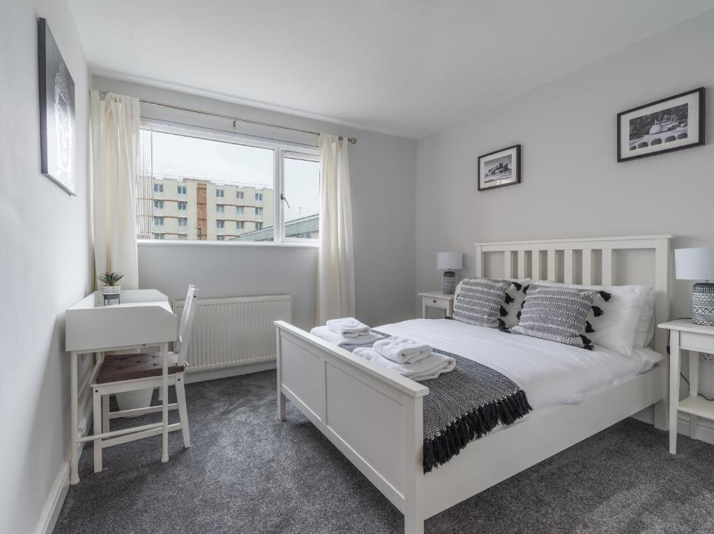 a white bedroom with a bed and a window at Charming 3-Bed House in Newcastle upon Tyne in Newcastle upon Tyne