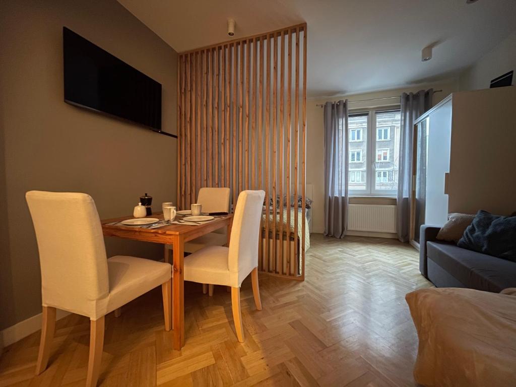 uma sala de estar com uma mesa de jantar e cadeiras em Bonifraterska 15 Studio - Old Town Apartment em Varsóvia
