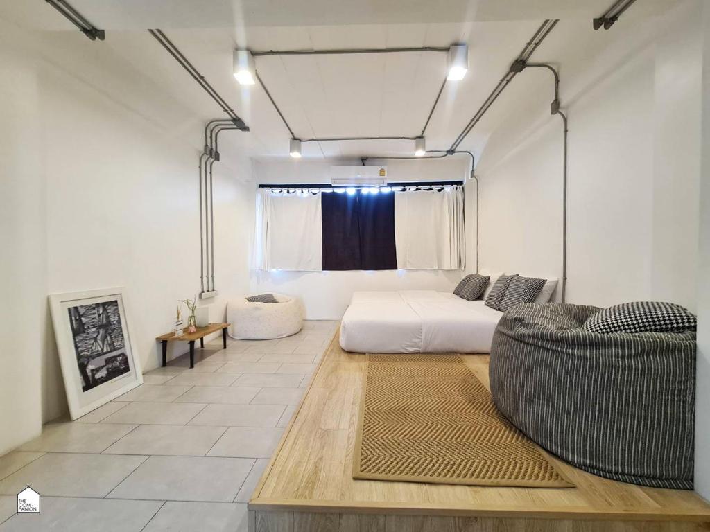 ein Wohnzimmer mit einem Bett und einem Sofa in der Unterkunft The Companion in Bangkok