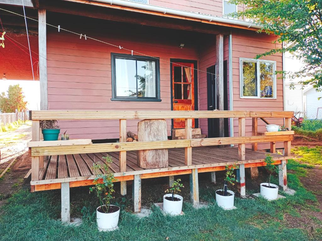 a wooden bench in front of a house at Habitación Chilota in Castro