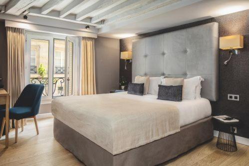 a large bedroom with a large bed and a desk at Hotel Opéra Marigny in Paris