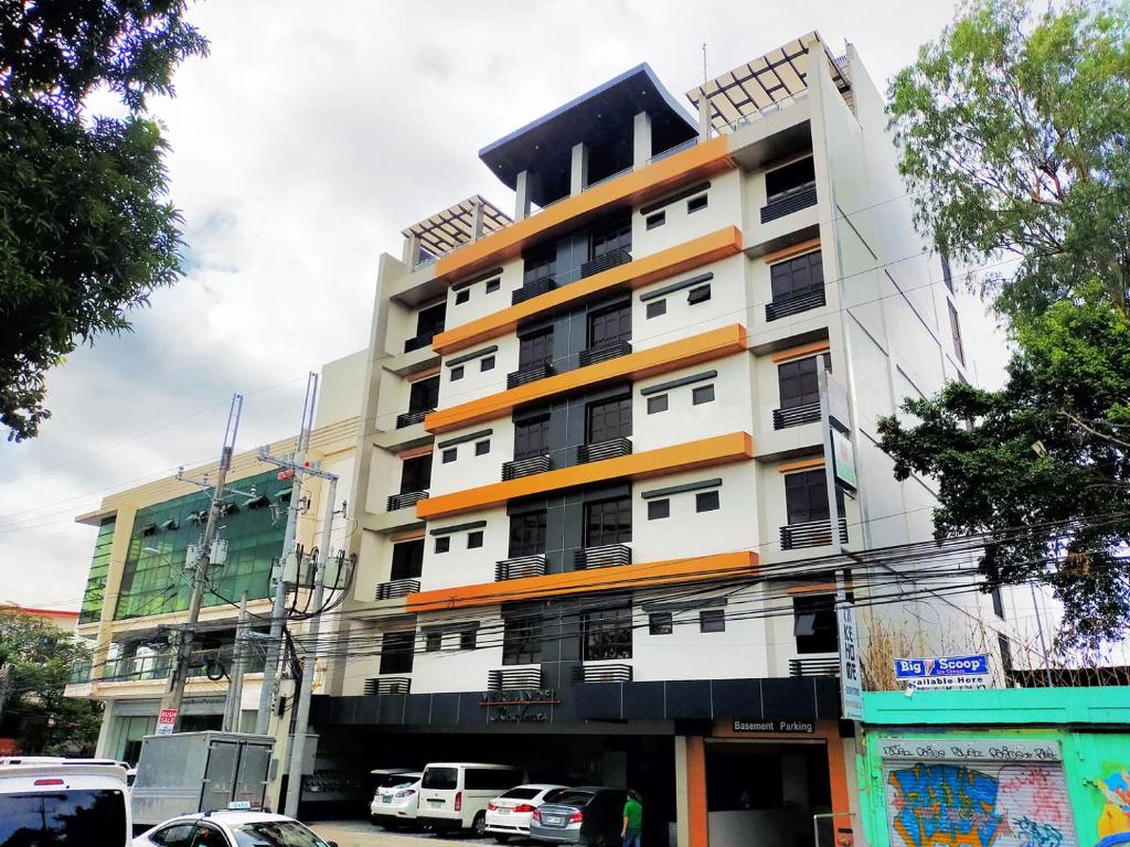 un edificio alto con macchine parcheggiate di fronte di Verjandel Residences a Manila