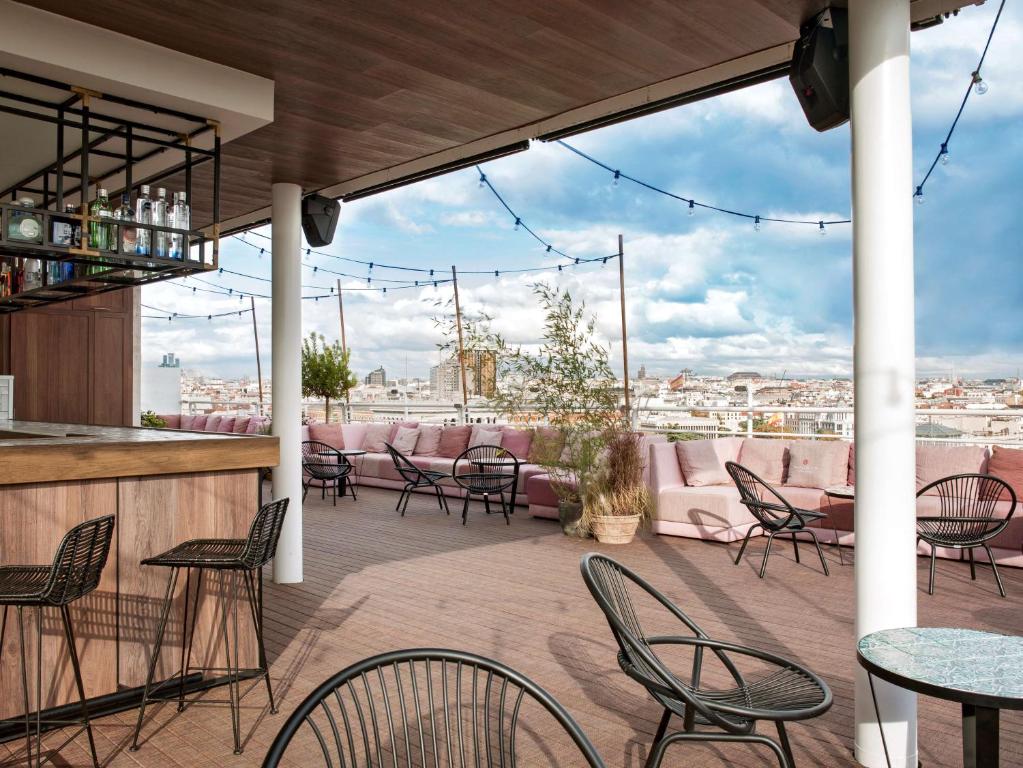 a patio area with tables, chairs and umbrellas at NH Collection Madrid Suecia in Madrid
