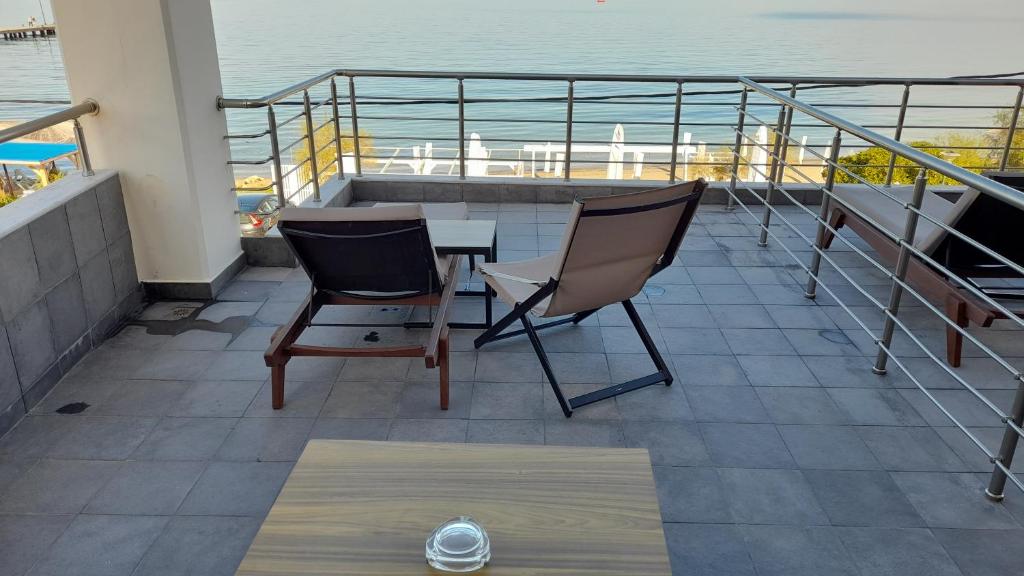 einen Balkon mit einem Tisch, 2 Stühlen und Meerblick in der Unterkunft Cabo Verde in Agía Triás