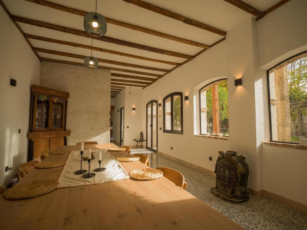 a large room with a wooden table and some windows at Casa de los Mendoza - Casa Solariega en el casco histórico in Alcalá de Henares