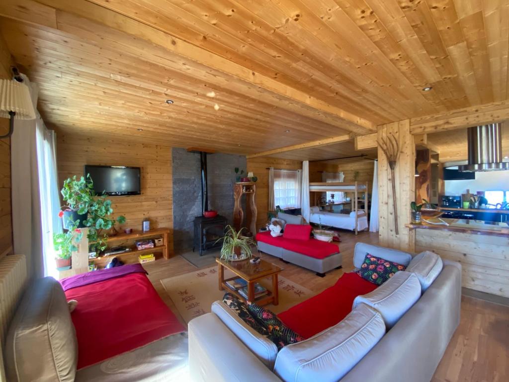 ein Wohnzimmer mit einem weißen Sofa und roten Kissen in der Unterkunft Chalet Miel de la Cayolle-Estenc in Entraunes