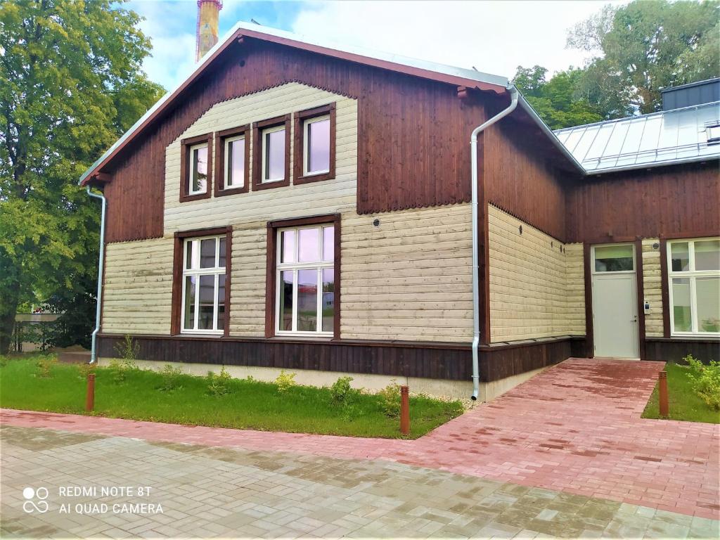 a house with a wooden building with a driveway at Dorpat Apartment in Tartu