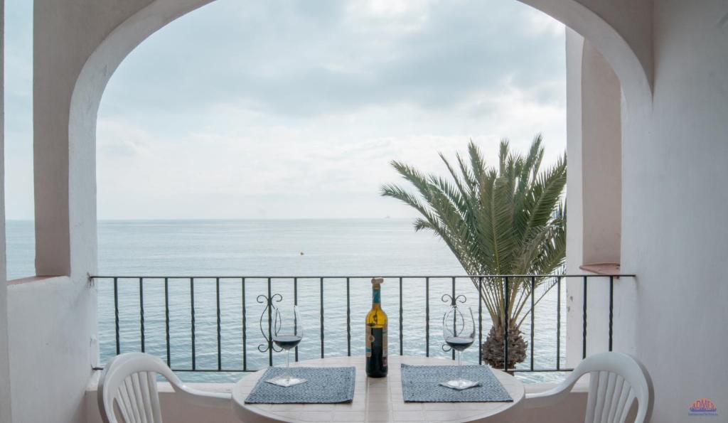 uma mesa com copos de vinho e vista para o oceano em Aldeas Taray Admer 12 em La Manga del Mar Menor