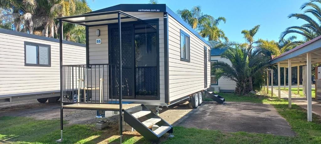a tiny house is parked next to a house at Shepparton Holiday Park and Village in Shepparton