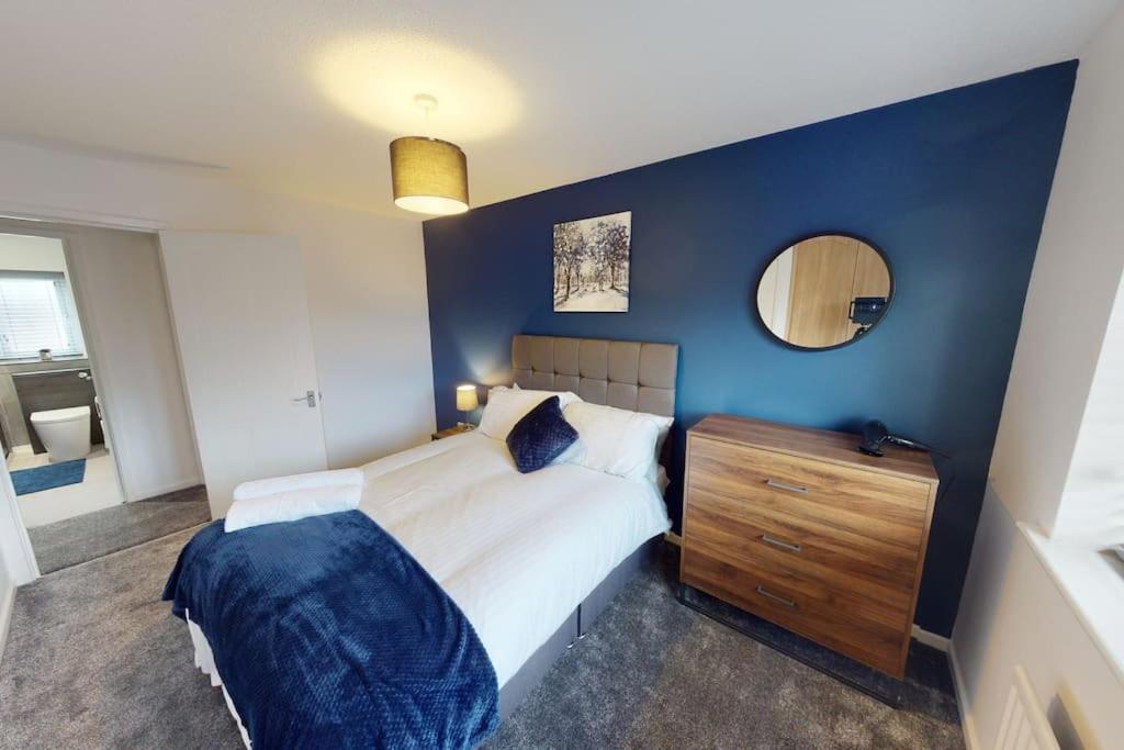 1 dormitorio con 1 cama grande y pared azul en HU-Nine Dock House - Sleeps 4 en Hull