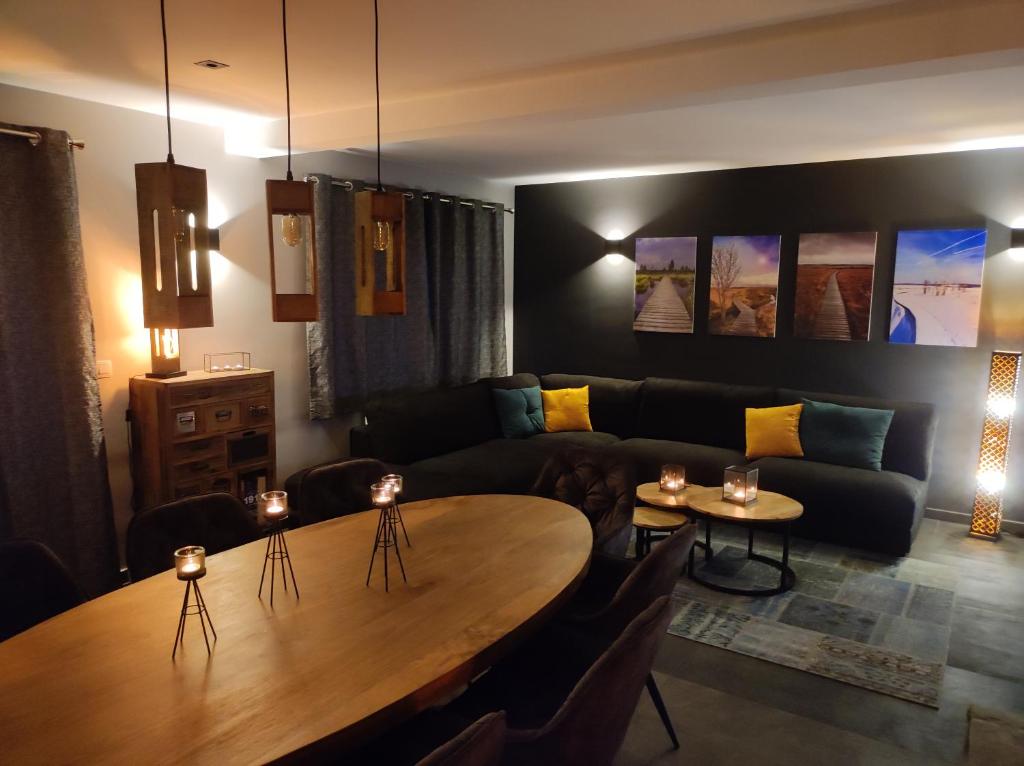 ein Wohnzimmer mit einem Tisch und einem Sofa in der Unterkunft Gîte La Renéade 