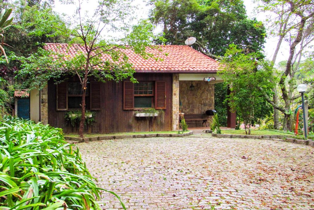 una casa con una entrada de ladrillo delante de ella en Casa de campo Azaleia c churrasqueira e lazer - RJ, en Teresópolis