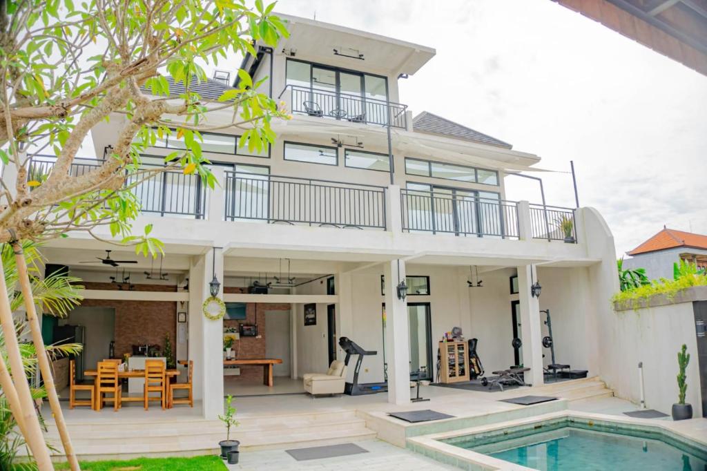 uma villa com uma piscina e uma casa em Berawa Homestay em Canggu