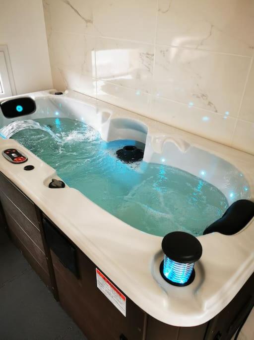 a bathroom with a tub with blue water in it at Jaccuzzi privatif dans studio tout confort in Lachapelle-sous-Aubenas