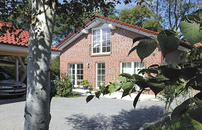 een stenen huis met een boom ervoor bij BIR9b Ferienwohnung Vahle in Niendorf