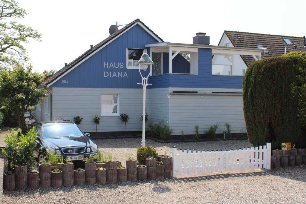 un'auto parcheggiata di fronte a una casa blu di STR90b Haus Diana a Niendorf