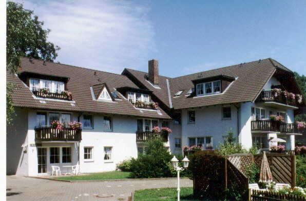 uma grande casa branca com flores nas varandas em TRA7e Residenz Windrose, App 13 em Niendorf