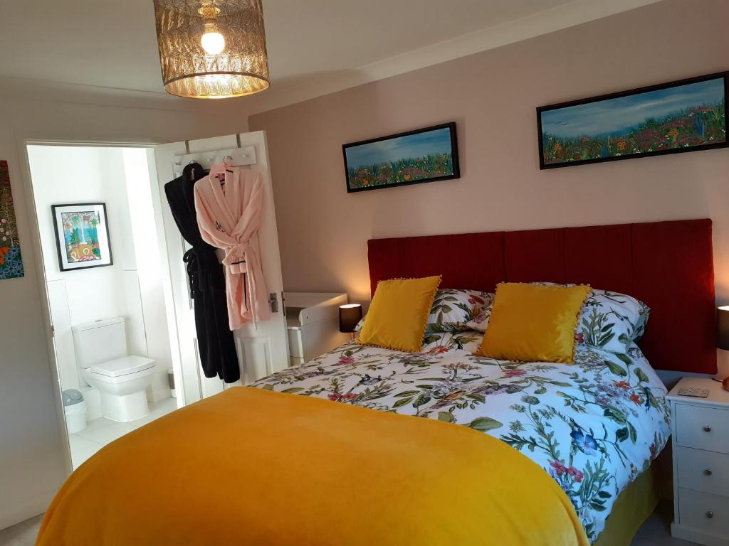 a bedroom with a bed with yellow pillows at Safe haven in Peacehaven