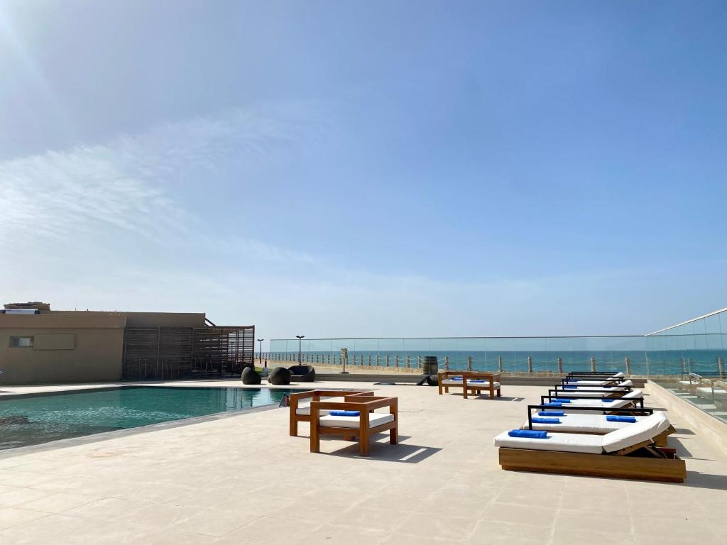 a row of lounge chairs next to a swimming pool at Tulum Beach Resort Dakhla in Dakhla