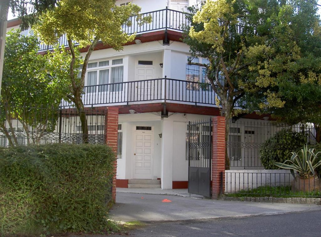 a white house with a balcony on top of it at Apartamentos Sarga Sentirgalicia in Cabañas