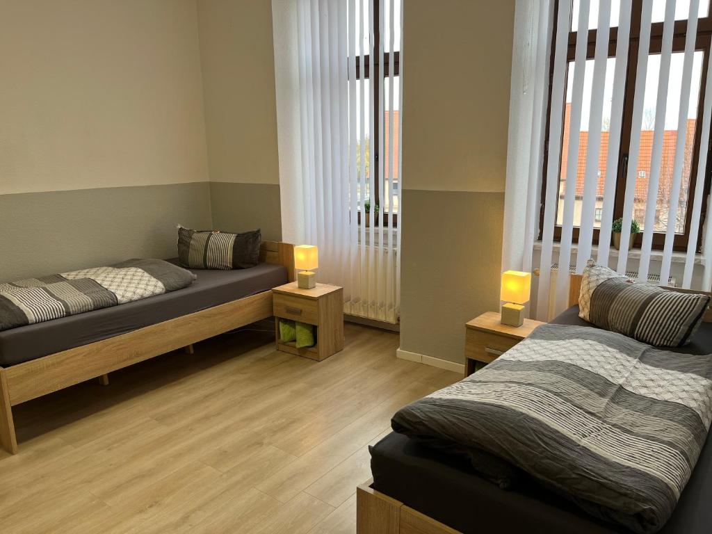 a room with two beds and two lamps in it at Ferienwohnung H&M Immobilien Alsleben 1 in Alsleben