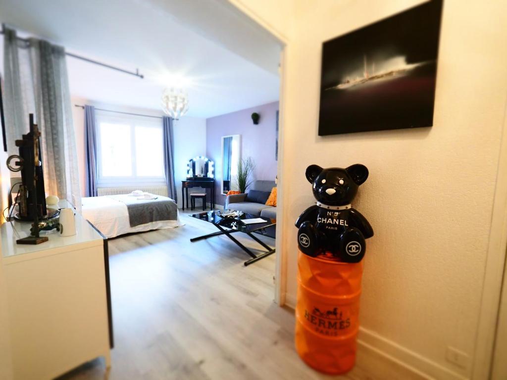 un ours en peluche dans un sac orange dans une pièce dans l'établissement LE CALLOU - Parking - Face aux Thermes - Rez de Chaussée, à Vichy