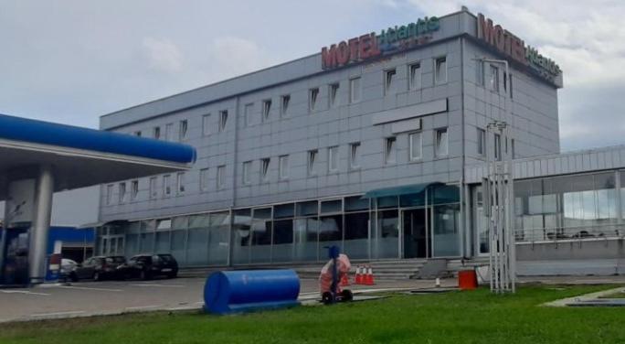 um grande edifício com uma pessoa à frente dele em Motel Atlantis em Prijedor