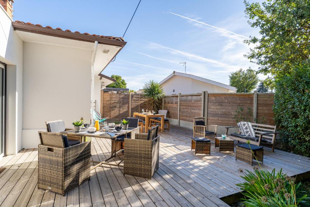 un patio con mesa y sillas en una terraza en Villa Nina- Maison cocon cosy, en La Teste-de-Buch