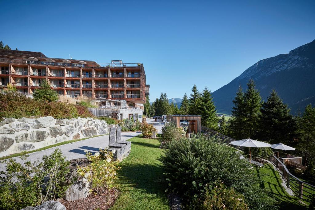 un hôtel dans les montagnes avec un jardin dans l'établissement Das Kronthaler - Adults only, à Achenkirch