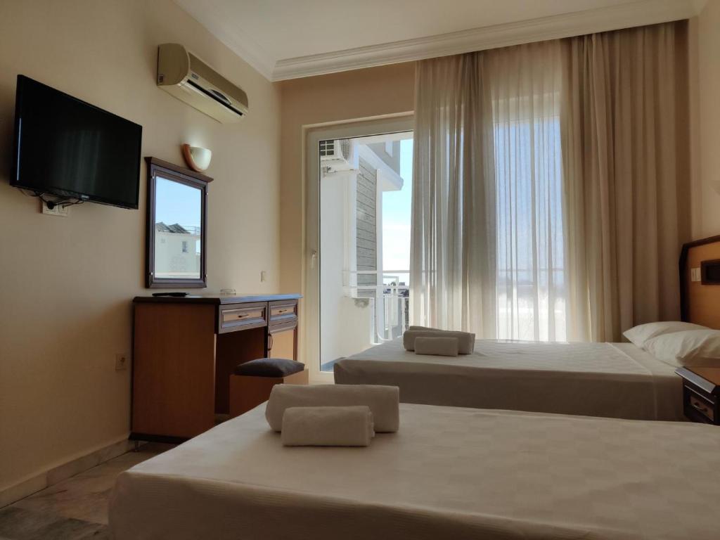 a hotel room with two beds and a television at Side Özgürhan Hotel in Side
