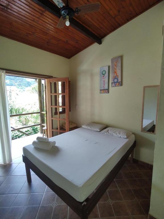 a large bed in a room with a window at Brisa Maresias in Maresias