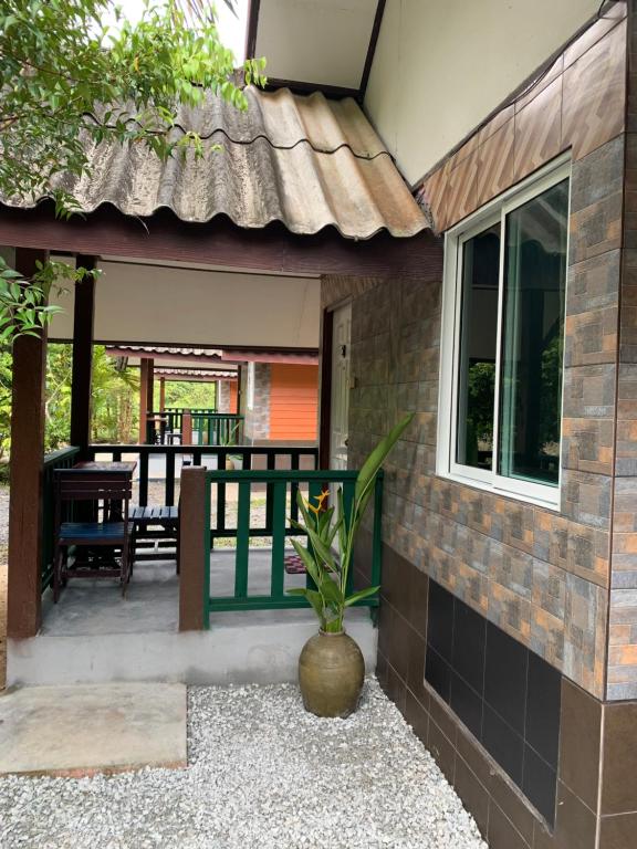 a house with a porch with a patio at Krua Chehe Resort ครัวเจ๊ะเห รีสอร์ท 