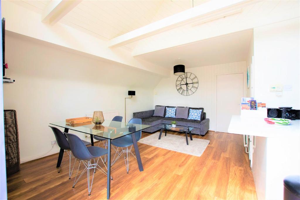 a dining room and living room with a table and chairs at The Penthouse Canterbury - Cathedral View in Canterbury