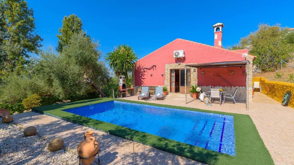 a house with a swimming pool and a red building at Casa Rural La Higuera El Gastor by Ruralidays in El Gastor